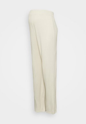 Calças largas de malha em tom creme com cintura elástica, apresentando uma textura suave e silhueta reta.