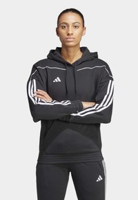 Zwarte hoodie met witte accenten en een drie-strepen ontwerp op de mouwen. Zacht materiaal met een voorzak en een verstelbare trekkoordcapuchon.