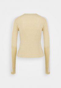 Pull beige côtelé à manches longues avec des rayures blanches courant le long des côtés extérieurs des manches, vu de dos.