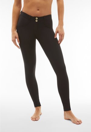 Leggings neri con una texture liscia, dotati di chiusura a doppio bottone in vita e cuciture curve lungo i fianchi.