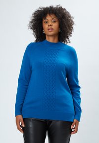 Maglione azzurro di lana lavorato a maglia con collo alto, orlo e polsini a coste, caratterizzato da un pannello centrale testurizzato con un motivo geometrico.