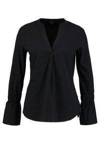 Blouse noire à manches longues avec un col à patte de boutonnage, poignets froncés, texture lisse et coupe décontractée.