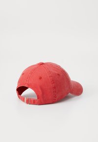 Rode katoenen baseballcap met een gebogen rand, verstelbare achterband en een licht versleten textuur. Zes-panel ontwerp met gestikte accenten.