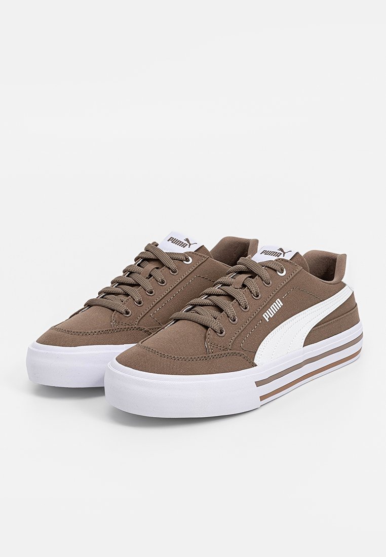 Zapatillas de lona marrones con acentos blancos, con un diseño de bajo, punta redonda y superficie texturizada. Cordones y detalle del logo en el lateral.