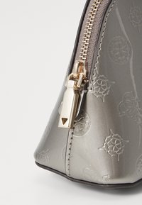 Gray patent leather bag with embossed floral patterns, featuring a gold zipper and hardware, tapering shape, and smooth texture.