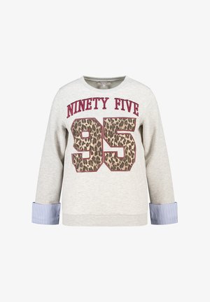 Sweat-shirt gris clair avec le texte "Ninety Five" et le numéro 95 en imprimé léopard, avec des poignets rayés bleus et blancs.