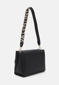 Sac en cuir noir avec une forme structurée, doté d'une bandoulière rehaussée d'or avec l'inscription "VALENTINO" et de détails en métal doré.