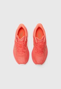 Zapatillas de running de malla coral con una parte superior texturizada, cordones a juego y una suela acolchada. Presenta un logo sutil en el costado.