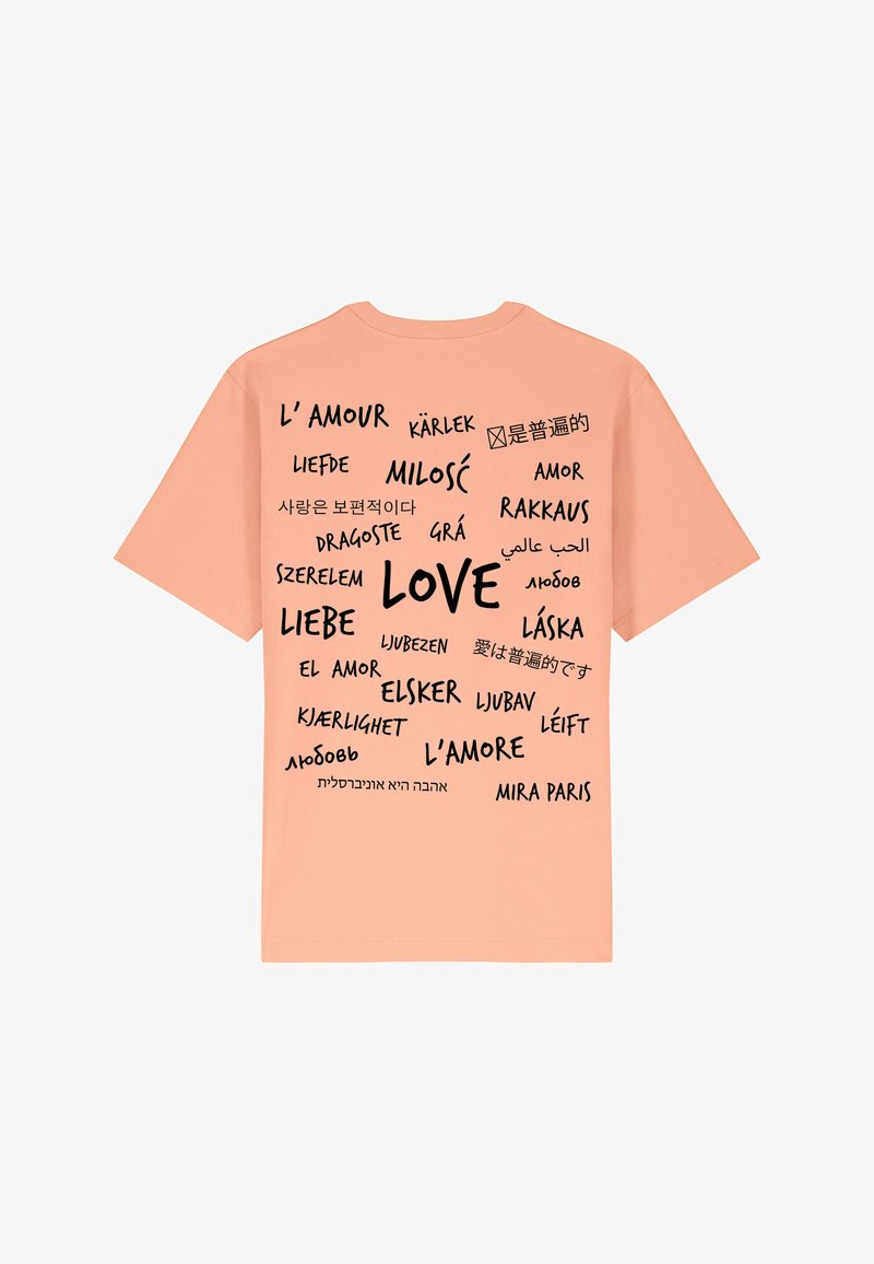 Perzikkleurig T-shirt met het woord "LOVE" in vetgedrukte zwarte letters, omringd door vertalingen in verschillende talen. Korte mouwen en casual.