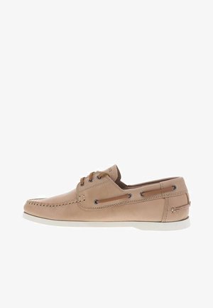 Chaussure bateau en cuir marron clair avec surpiqûres moc toe, laçage à l'avant, détail de laçage sur le côté et semelle en caoutchouc blanche.