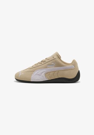 Baskets en daim beige avec un accent en cuir blanc, surface lisse, panneaux latéraux texturés et semelle en caoutchouc noire. Logo Puma sur le côté.