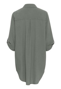 Grön, överdimensionerad skjorta med knappslå, bakveck, uppkavlade ärmar och rundad nederkant. Tillverkad av lättviktig tyg. Enkel design, inga mönster.