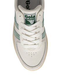 Chaussure de sport blanche avec des rayures vertes, en cuir texturé, à bout rond et avec des perforations pour la respirabilité. Logo Gola sur la languette.