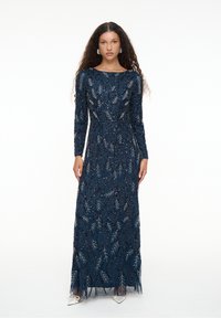 Langes navyblaues Kleid mit langen Ärmeln, verziert mit silbernen Blattmustern und zarter Perlenstickerei, mit tailliertem Schnitt und fließendem Rock.