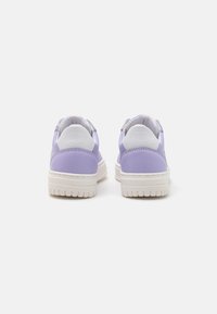 Lilac sneakers with a smooth texture, white heel accents, and patterned rubber sole. Designed with soft materials for comfort.