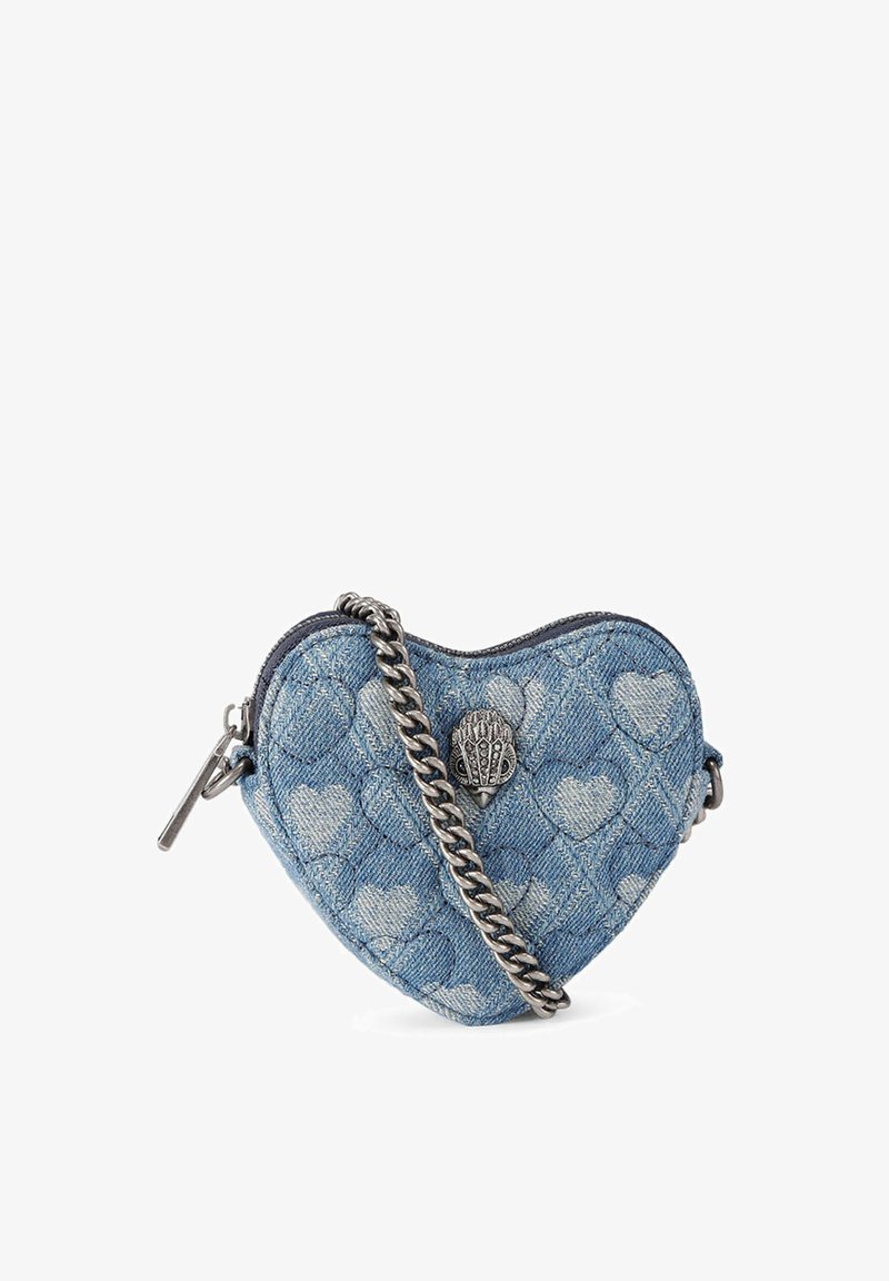 Sac à main en jean bleu en forme de cœur avec un design matelassé présentant des motifs de cœurs blancs, une bandoulière en chaîne argentée et un détail de fermoir en métal.