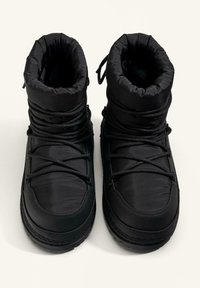 Crne izolirane zimske čizme s podstavljenim gornjim dijelom, sustavom vezanja i teksturiranim gumama. Glatka tkanina i usklađena boja kroz cijeli model.