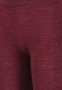 Burgunderfarbene Leggings aus einem strukturierten Strickmaterial, mit engem Sitz und verstärkten Nähten für Langlebigkeit.