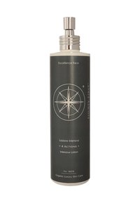 Schwarze zylindrische Flasche mit silbernen Akzenten, beschriftet mit "Excellence Face" und "Intensive Lotion". In der Mitte befindet sich ein Kompassdesign.