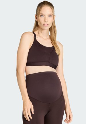 Schwarzer sportlicher Umstands-BH mit verstellbaren Trägern und glattem, dehnbarem Material. Kombiniert mit hoch taillierten passenden Leggings.