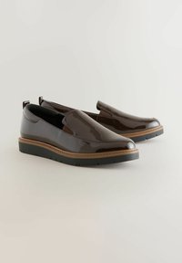 Scarpe slip-on in pelle verniciata marrone con punta arrotondata, suola intermedia di un marrone chiaro a contrasto e suola in gomma testurizzata per una migliore aderenza.