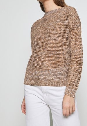 Hellbrauner, gestrickter Pullover mit langen Ärmeln und rundem Halsausschnitt. Die Textur ist offen gestrickt, was eine atmungsaktive, geschichtete Optik erzeugt.