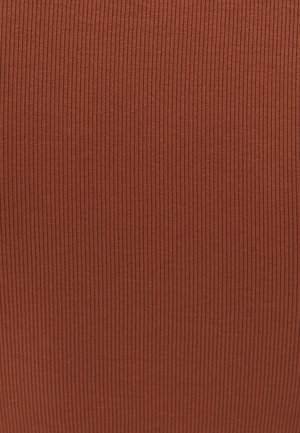 Tissu côtelé dans une couleur terracotta chaude, présentant une surface texturée avec des lignes verticales régulièrement espacées. Matériau doux et extensible.