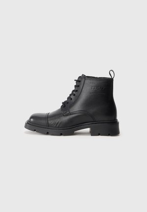 Black leather lace-up ankle boot with sturdy sole and branded logo on the side, designed for casual or rugged wear.