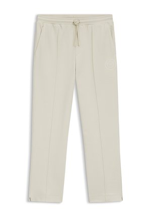 Light beige sweatpants with a drawstring waistband, side pockets, and subtle stitching details, featuring a small logo on the thigh.