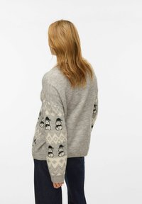 Hall halli kudumisest kampsun lumehelvesemustriga varrukatel, pehme tekstuuri ja mugava lõikega, vaadatuna tagantpoolt.