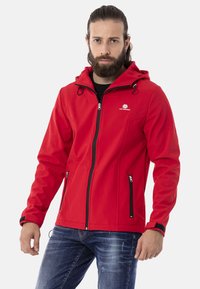 Rote Softshell-Jacke mit Kapuze, durchgehendem Reißverschluss, zwei Seitentaschen, schwarzen Reißverschlussakzenten und verstellbaren Kordel-Details. Schlichtes Design.