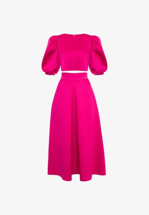 Jasnoróżowy dwuczęściowy strój z wyraźnymi rękawami do łokcia i wysokim stanem, z szerokimi nogawkami i plisą z przodu.