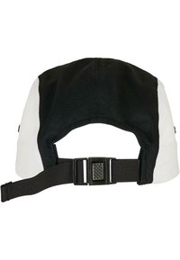 Casquette noir et blanc avec un bord courbé, équipée d'une sangle en tissu et d'une boucle en plastique ajustable à l'arrière. Matière en coton texturé.