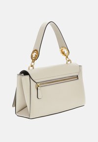 Borsa a tracolla in pelle beige con una forma strutturata, dettagli in metallo dorato, una tasca con zip e una maniglia removibile caratterizzata da anelli circolari.