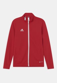 Rød zip-up jakke med en mock krave, to sidelommer og hvidt Adidas-logo. Har en glat tekstur og athletic fit.