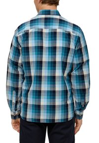 Blauwe geruite blouse met variërende tinten blauw, wit en donker marineblauw in vierkantjes. Lange mouwen met knoopmanchetten en een gebogen zoom.