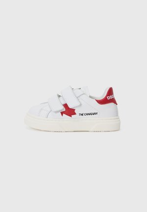 Zapatilla blanca con dos tiras de Velcro, acento de hoja de arce roja y texto "EL CANADIENSE". Suela de goma con detalles texturizados.