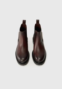 Bottines Chelsea en cuir marron avec une finition lisse, des panneaux latéraux élastiques, des tirants et de épaisses semelles en caoutchouc noir pour une meilleure adhérence.