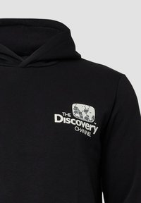 Zwarte hoodie met een wit Discovery Channel-logo dat een gestileerde globe op de borst toont, weergegeven tegen een effen grijze achtergrond.