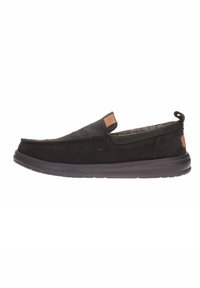 Zapatos negros sin cordones con tela texturizada, puntera redonda, cuello acolchado y etiqueta de logo discreta. Suela de goma gruesa para mayor comodidad y agarre.