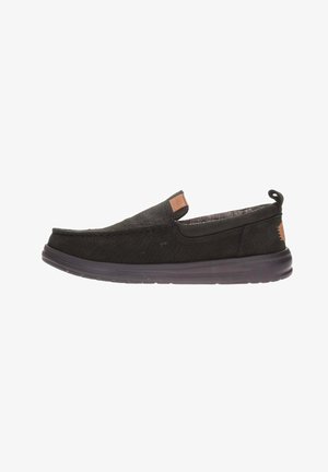 Scarpe slip-on nere in tessuto testurizzato, punta tondeggiante, collo imbottito e etichetta logo discreta. Suola in gomma spessa per comfort e aderenza.
