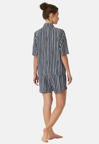 Marinblå och krämfärgad randig pyjamasset med kort ärm, bestående av en skjorta med krage och shorts. Lättviktigt tyg med avspänd passform och uppvikta ärmar.