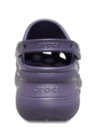 Paarse Crocs van rubbermateriaal, met een achterband, een dikke zool en ventilatiegaatjes. Kenmerken zijn het reliëf "CROCS" logo op de hiel.