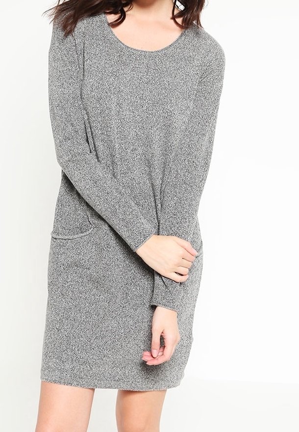 Femme portant une robe en maille grise à manches longues, longueur genou, avec un col rond et une petite poche sur le côté gauche.