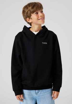 Zwarte hoodie met een buidelzak en geribbelde cuffs, met het logo "T.W.S.N." in het wit op de linker borst. Draagt met lichtblauwe jeans.