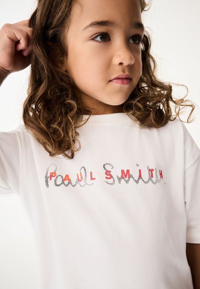 Bílá bavlněná trička s potiskem "PAUL SMITH" v černých tečkách s červenými akcenty. Krátké rukávy a volný střih. Jednoduchý design s kulatým výstřihem.