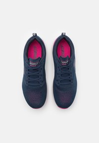 Zapatillas deportivas de color azul marino con acentos rosas; parte superior de malla trenzada para mayor transpirabilidad; diseño con cordones; suela plana con banda de rodadura texturizada.