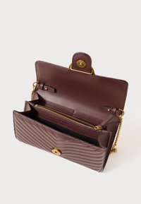 Portafoglio in pelle bordeaux con design trapuntato, accessori in oro, chiusura a scatto magnetico e tasca interna con zip. Forma strutturata e compatta.