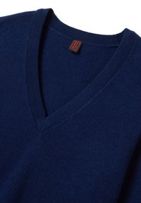 Maglione a V blu navy realizzato in tessuto morbido, con scollatura a coste e un'etichetta con lettering rosso. Texture liscia e design classico.