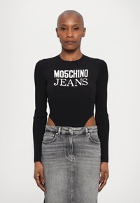Bodysuit preto com textura canelada e aberturas laterais exibindo o texto branco "MO5CH1NO JEANS"; combinado com uma saia lápis de denim cinza.